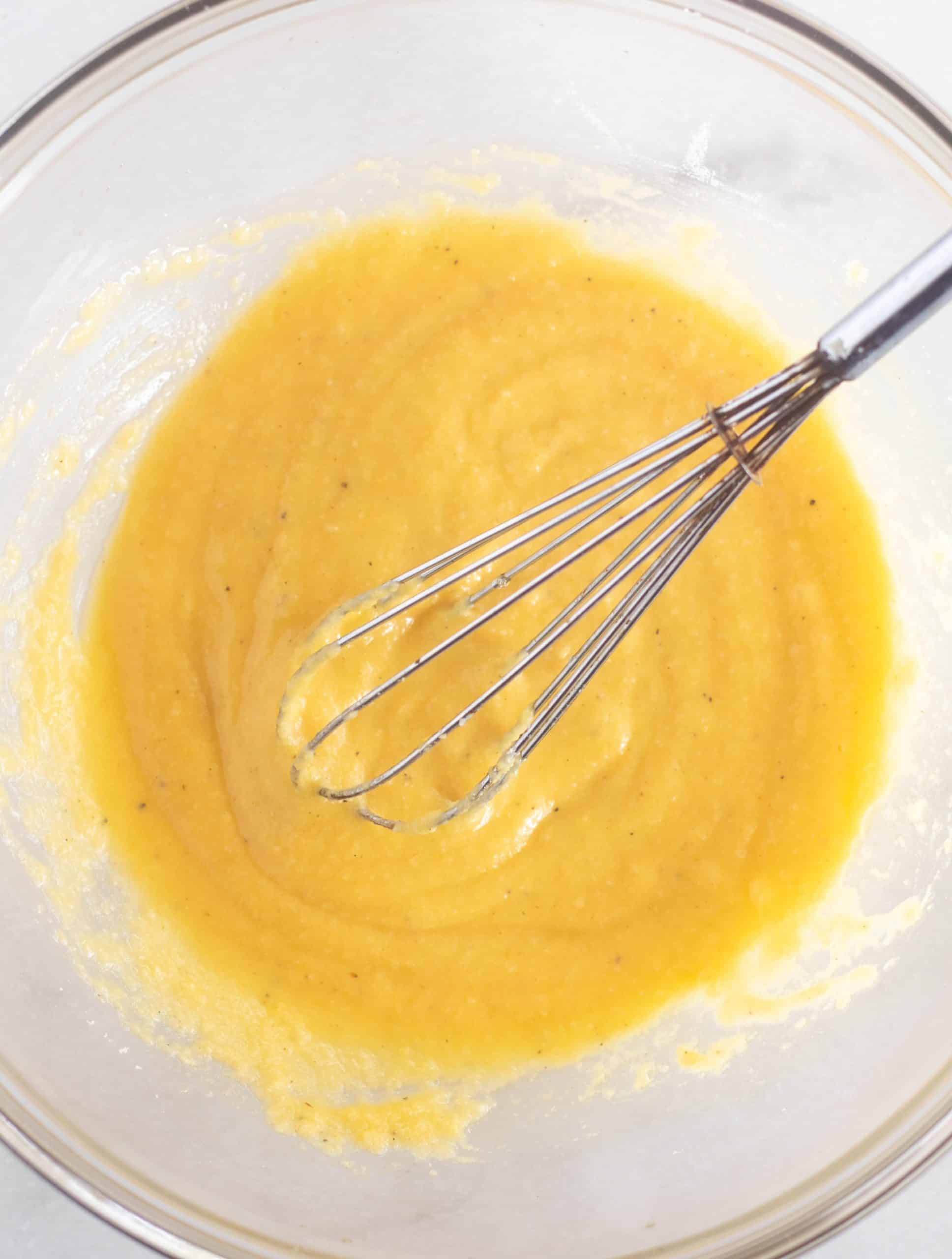 batter for bread with a whisk in a clear bowl.