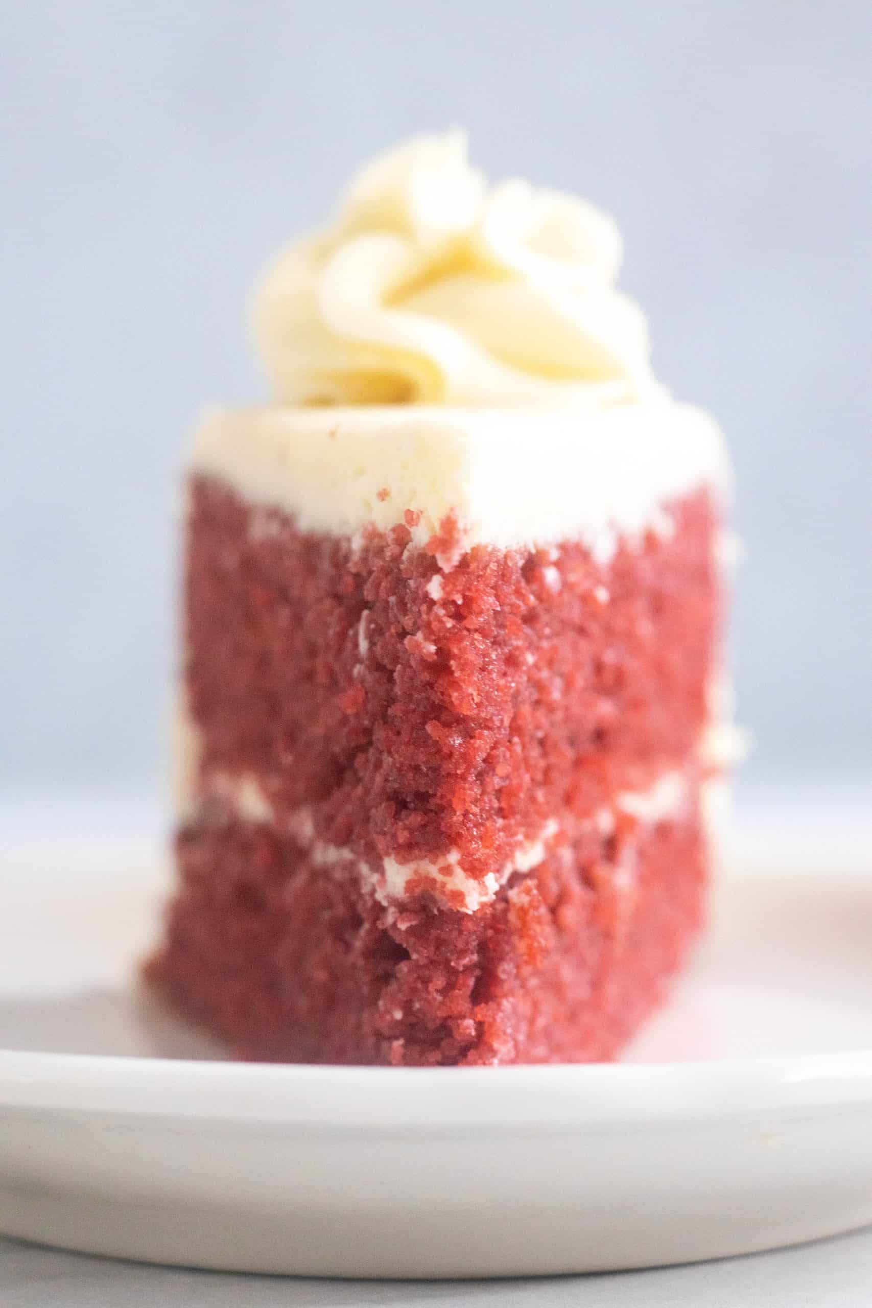 close up of a slice of red velvet cake standing upright