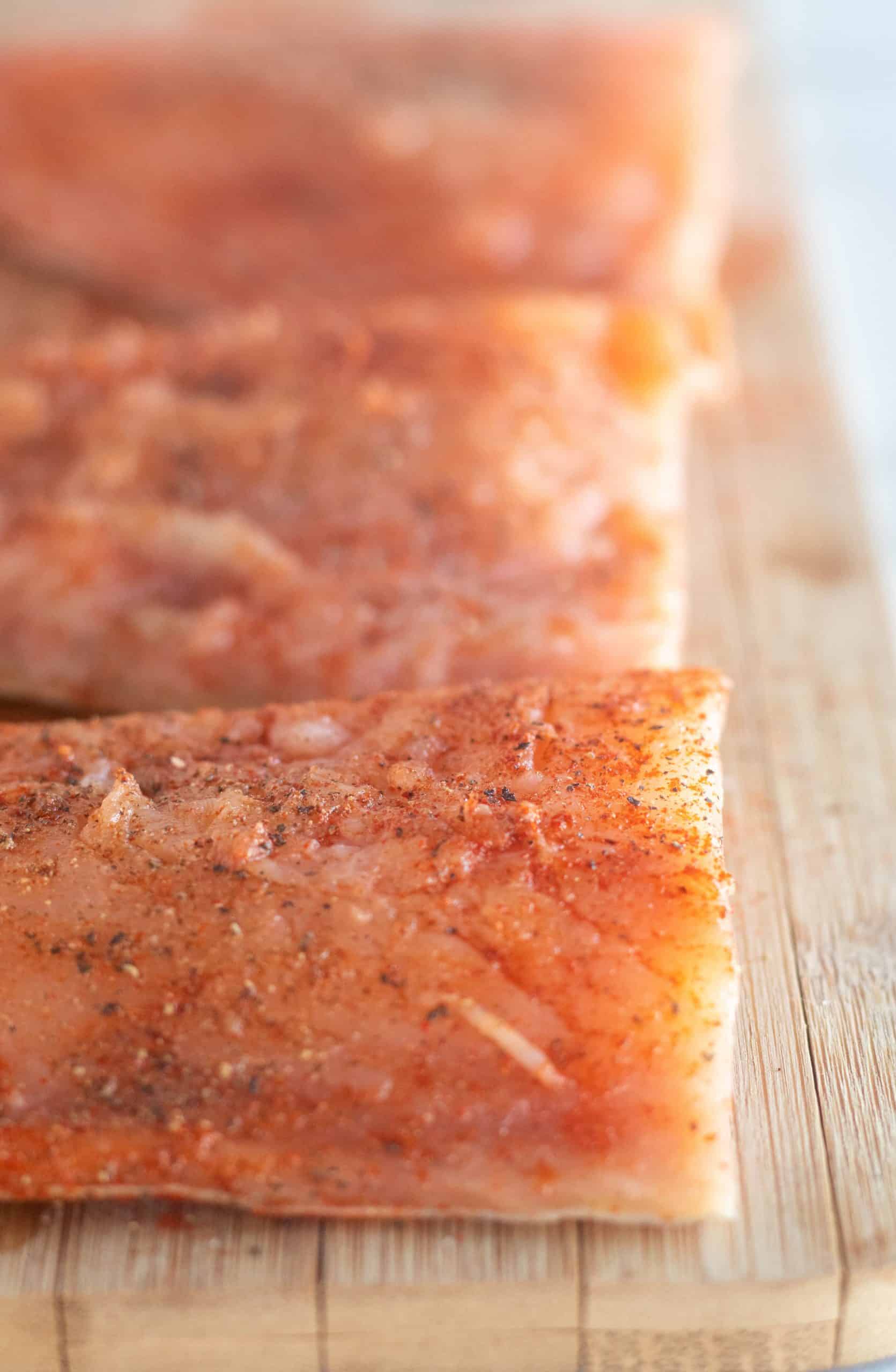 close up of uncooked, seasoned salmon