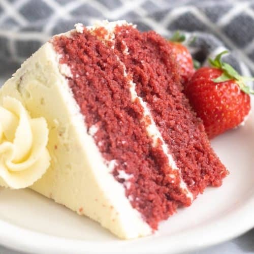 slice of red velvet cake on a white plate with strawberries