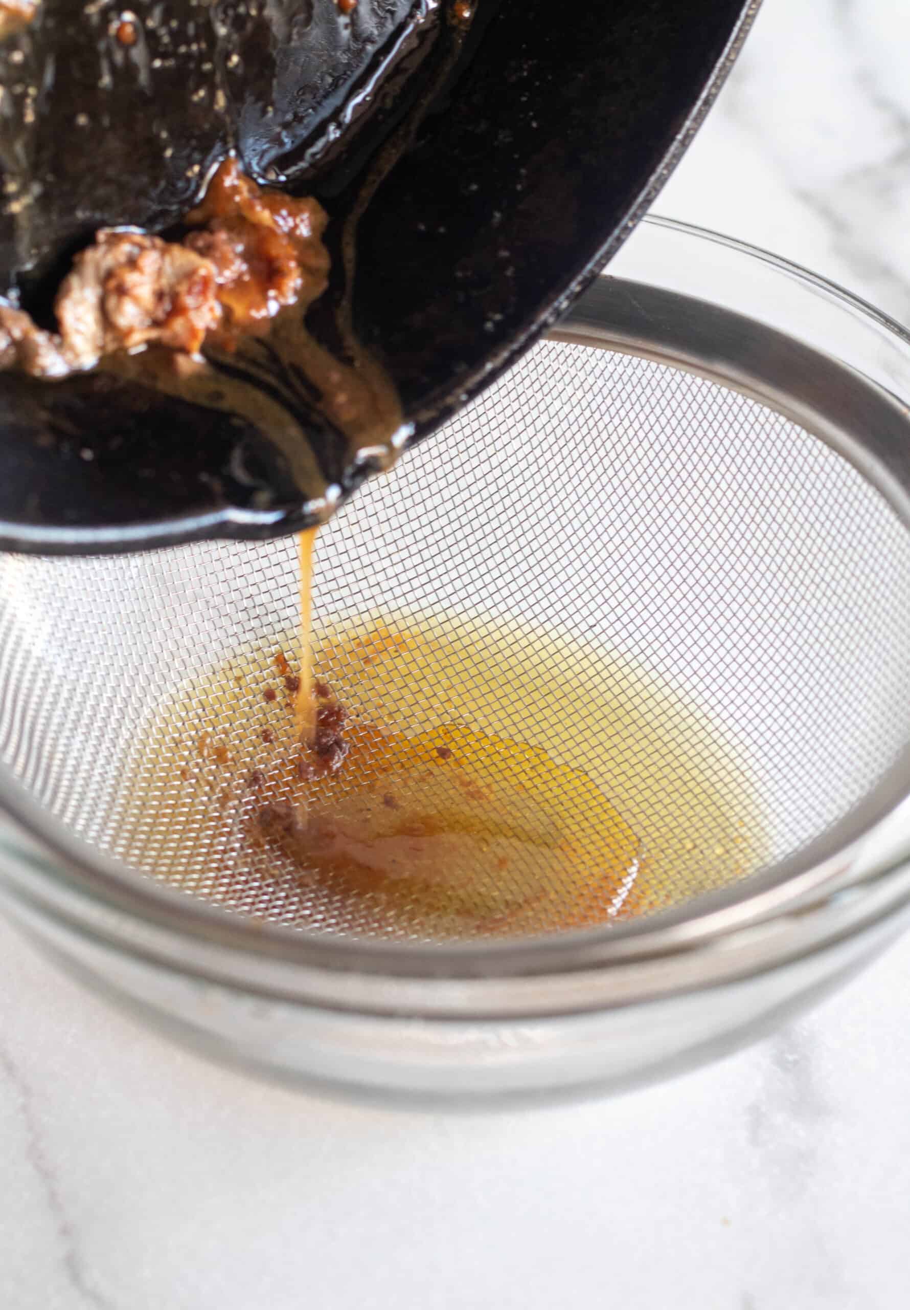 pouring drippings through a strainer