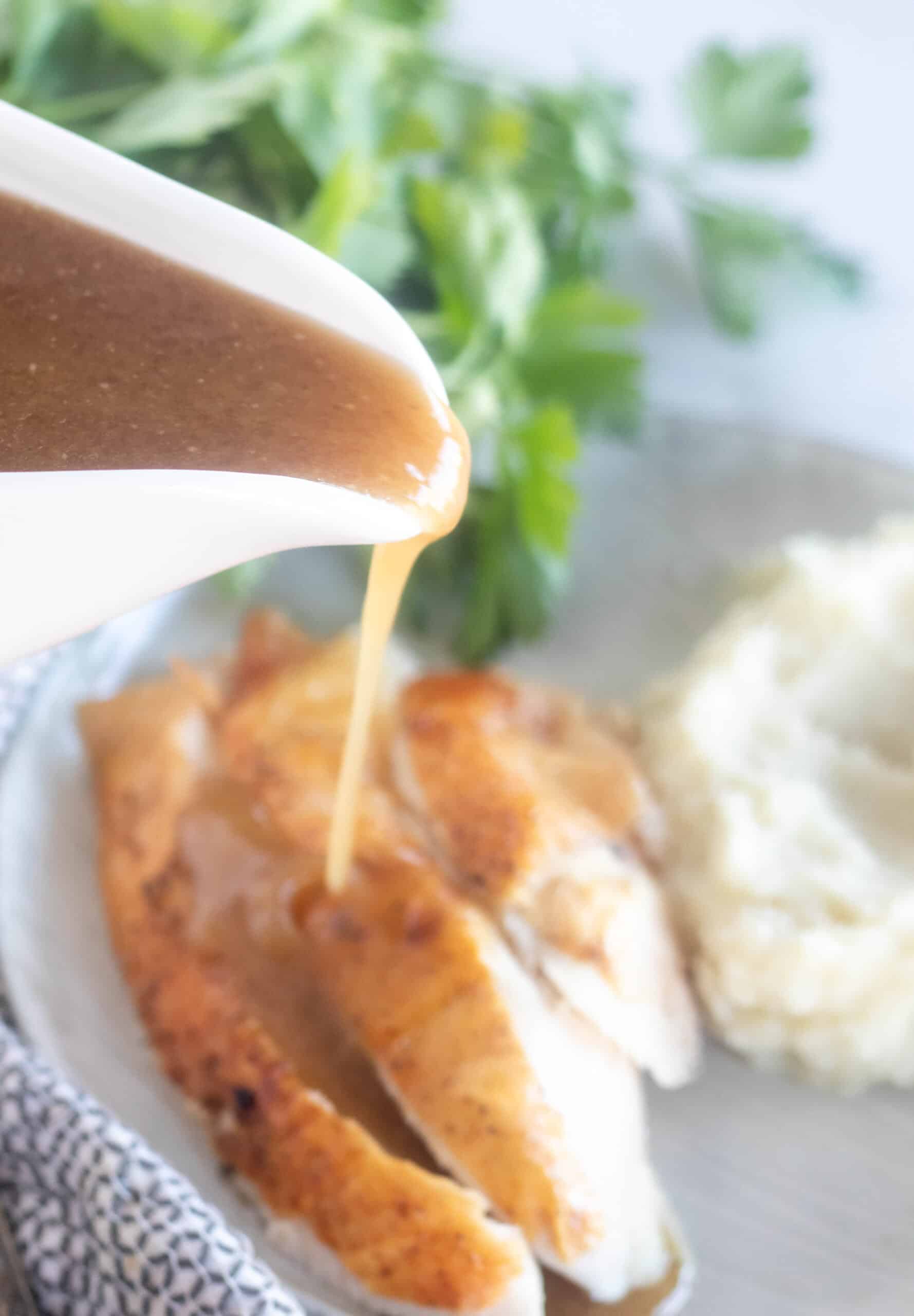 pouring gravy over chicken
