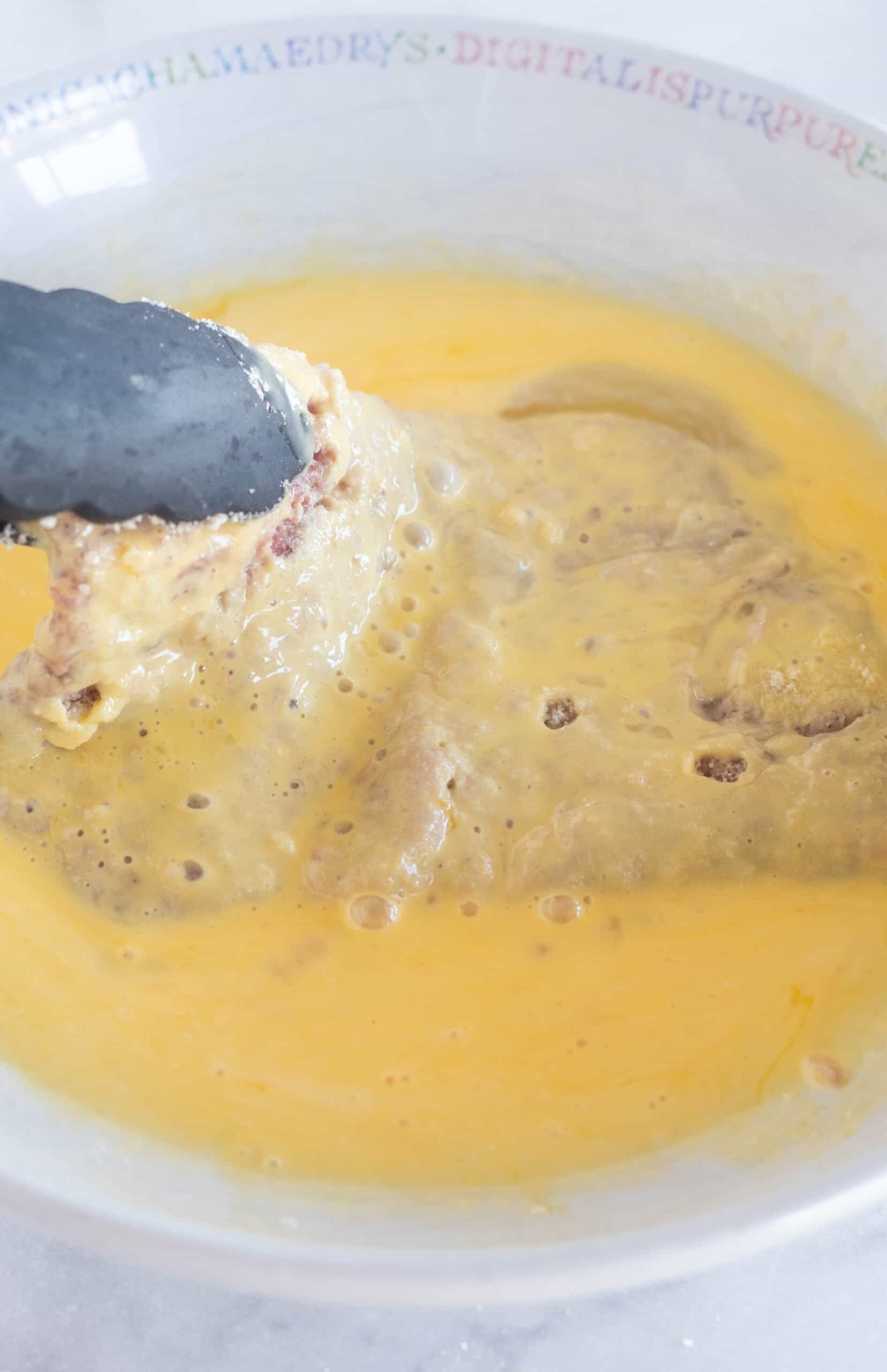 dredging meat in egg mixture.