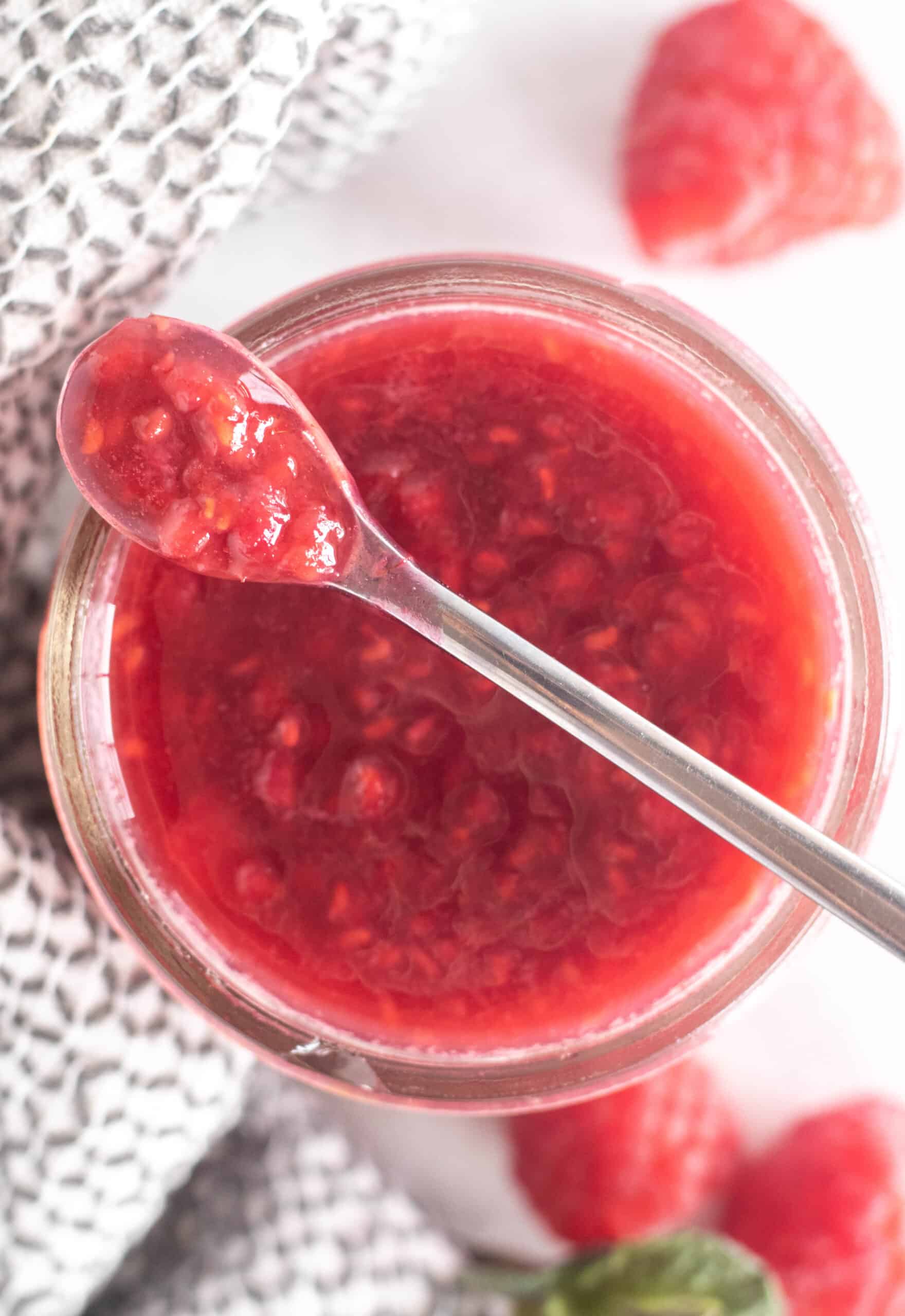 overhead shot of raspberry sauce in a small mason jar.