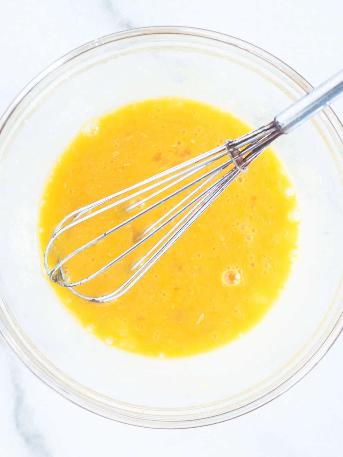 whisked eggs in a clear bowl.