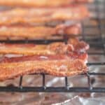 square image of cooked bacon on a cooling rack.