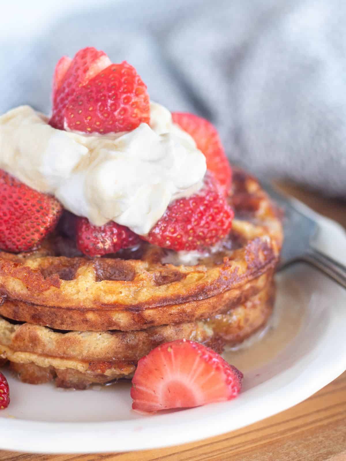 close up of chaffles with whipped cream and berries.