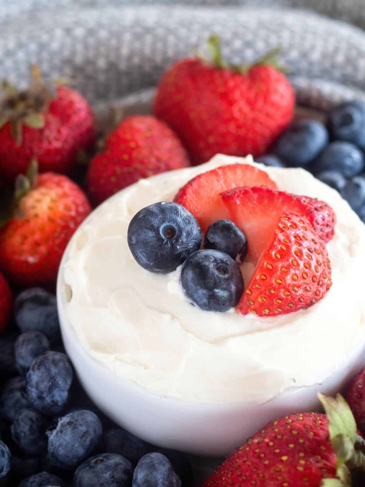 close up of fruit dip with berries on top.