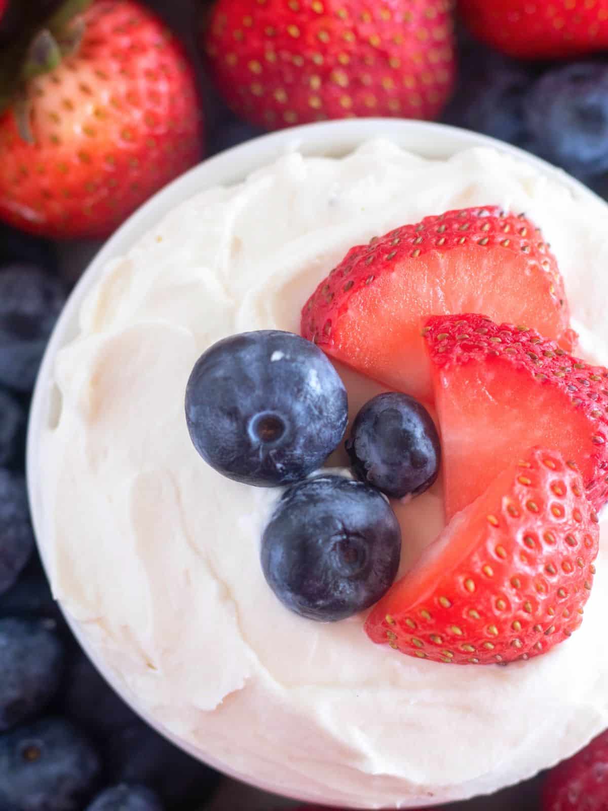close overhead shot of low-carb fruit dip in a bowl with berries.