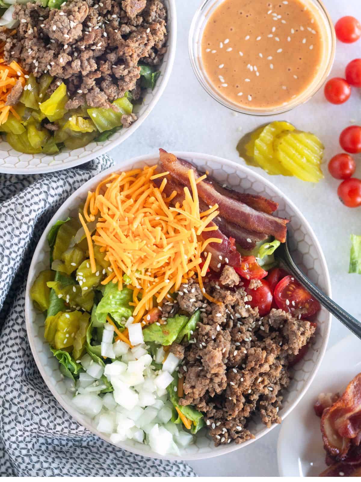 overhead shot of cheeseburger bowl with garnishes.